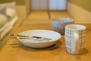 A dining table with a bowl, a mug, and cutlery. - Guesthouse ZenNichi (Kyoto)