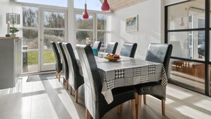 Comedor con una mesa grande, sillas y vistas al exterior.