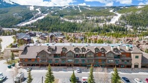 A lodge with a central building surrounded by parking and a ski slope in the background. - 4 Bedroom Condo at Gateway Lodge Near Mountain House Base (Keystone)