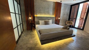 A modern bedroom with a bed, bedside lamps, a chair, and a view through a window.