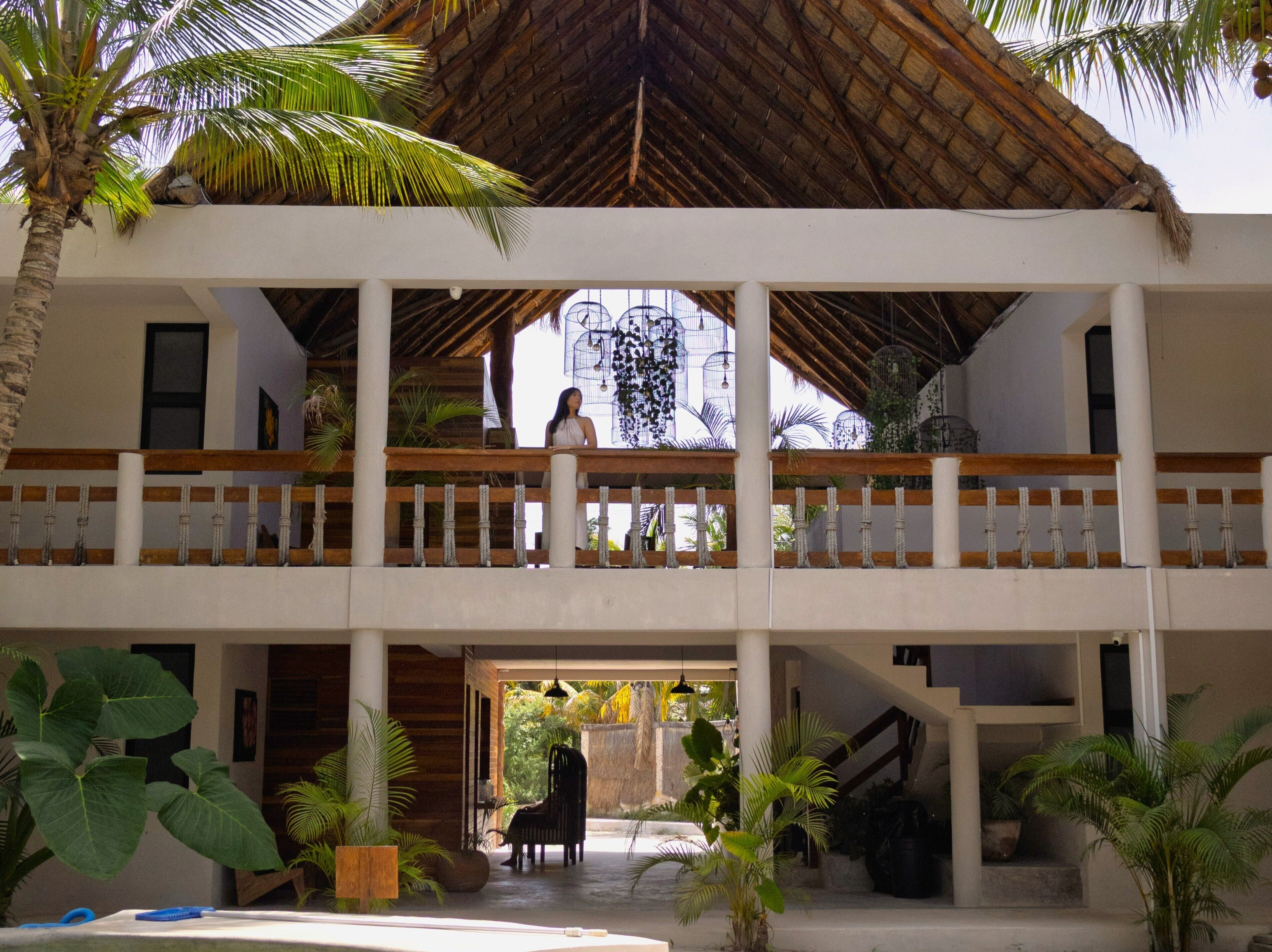 A multi-level building with a thatched roof, balconies, and indoor seating areas.