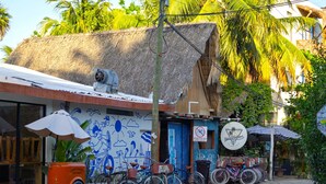 Un edificio con un mural, bicicletas estacionadas afuera y un letrero de alquiler de bicicletas.