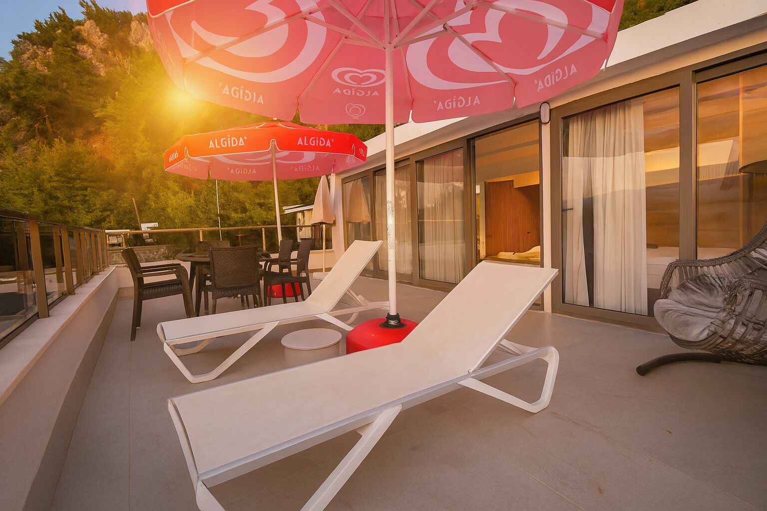 A rooftop terrace with outdoor seating, including lounge chairs and tables, and umbrellas branded with "Agidia".