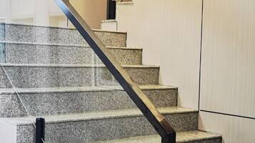 A staircase with a metal handrail and a glass railing.