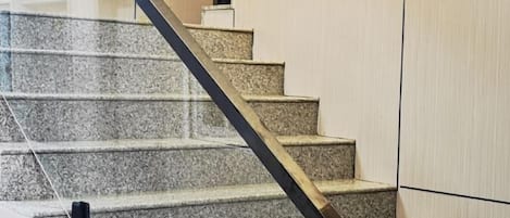 A staircase with a metal handrail and a glass railing.