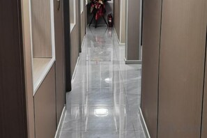 A corridor with a shiny floor, flanked by walls with a light-colored finish. - Yuzhong Senshu Business Hotel (Yuzhong)