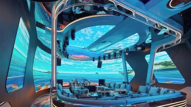 Un intérieur luxueux avec un espace salon aux lignes courbes, de grandes fenêtres et une vue sur l’océan.