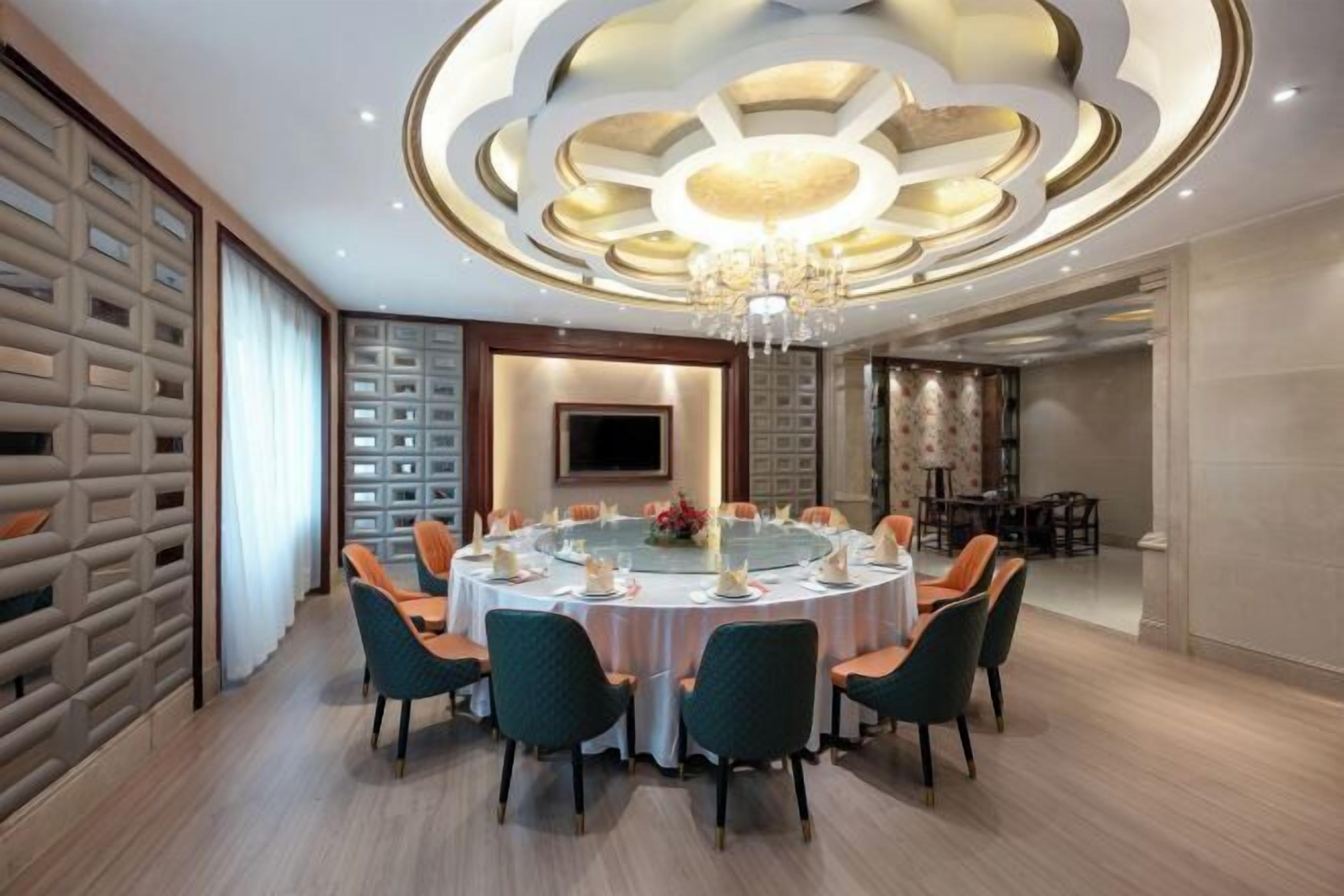 A dining area with a round table set for six, surrounded by chairs.