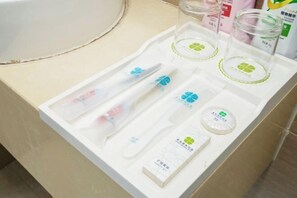 A bathroom counter with a white tray containing a toothbrush, toothpaste, a comb, a razor, and a soap bar. - Changtai Hezheng Business Hotel (Zhangzhou)
