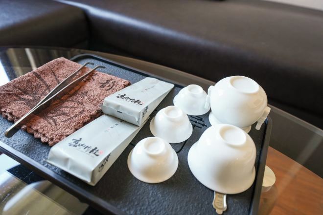 A tray with a chocolate bar, white cups, and a napkin on a table.