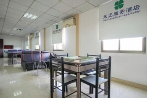 A hotel room with a bed, a desk, and a chair. There are windows and a door. - Changtai Hezheng Business Hotel (Zhangzhou)