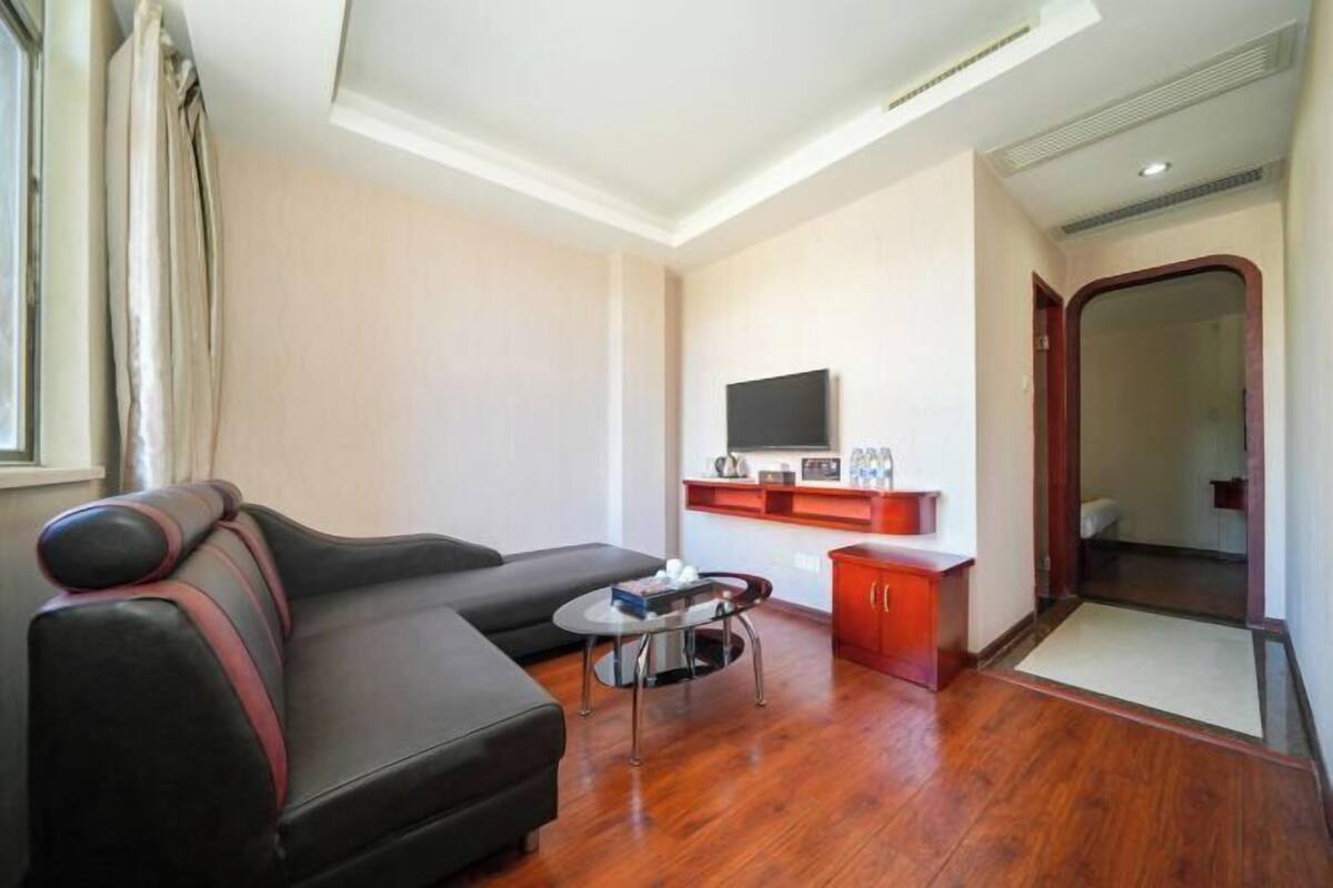 A modern living room with a sofa, a small table, a TV, and a cabinet.