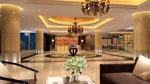 A spacious lobby with a central seating area, a chandelier, and a decorative vase with flowers. - Western Regions Spring Hotel (Wensu)