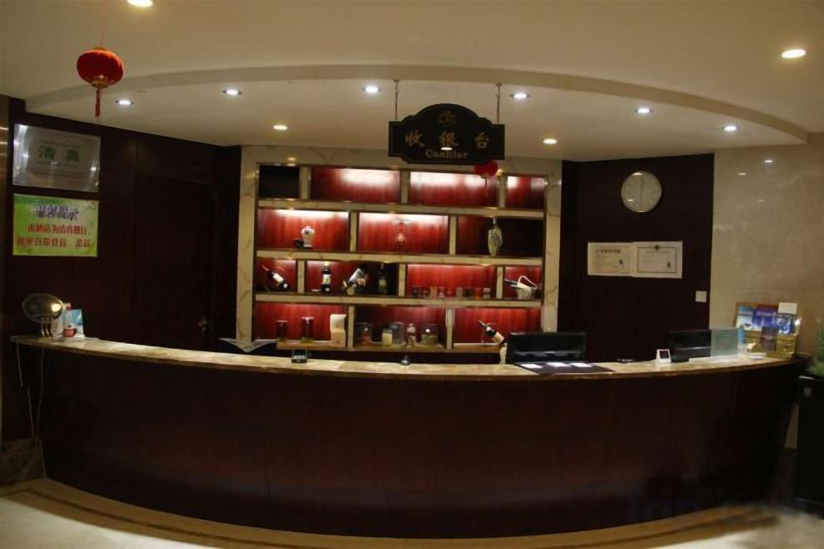A reception desk with a curved design, a clock on the wall, and a sign above it.