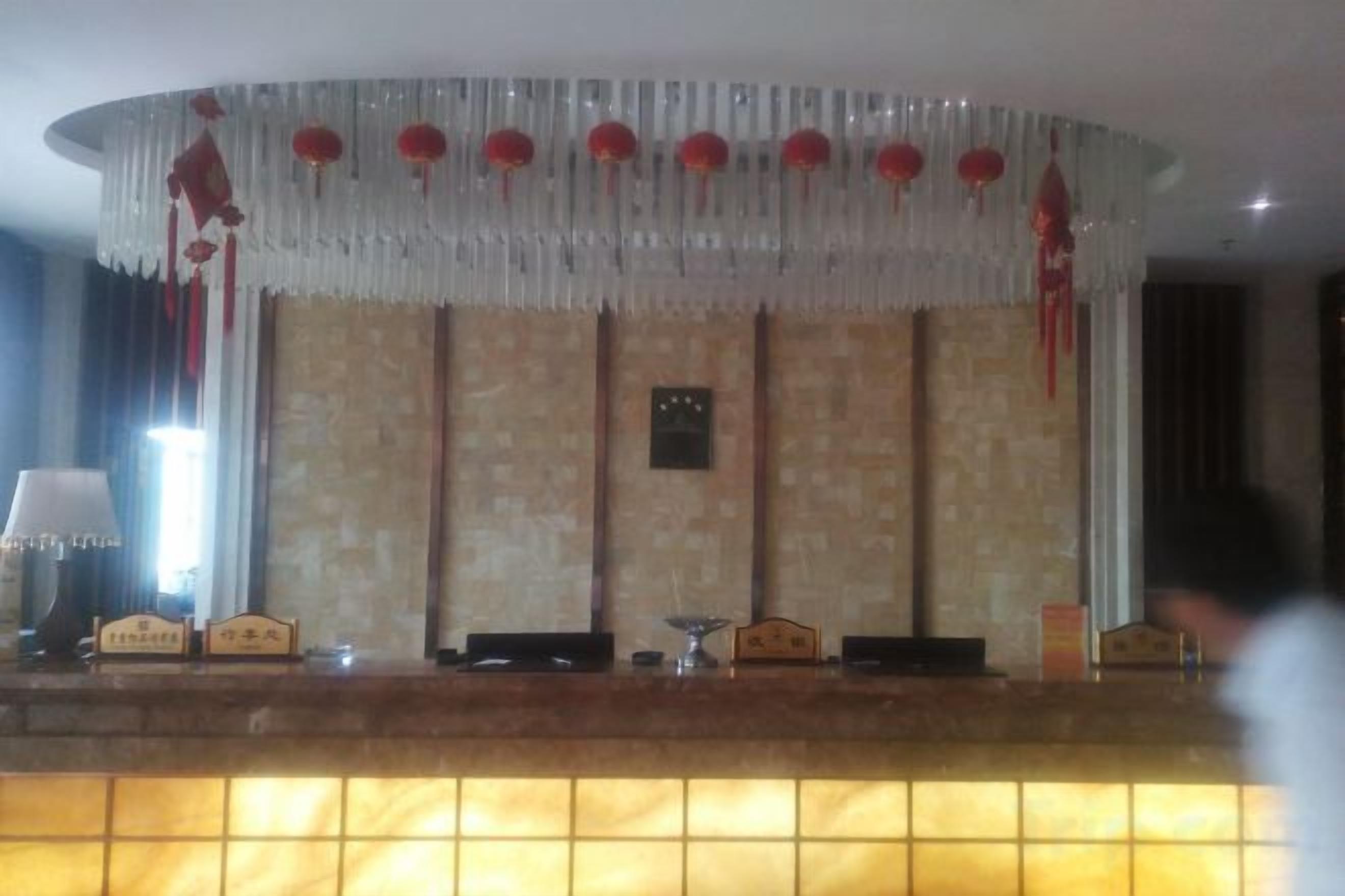 Un'area di accoglienza con reception, orologio a parete e soffitto decorato.