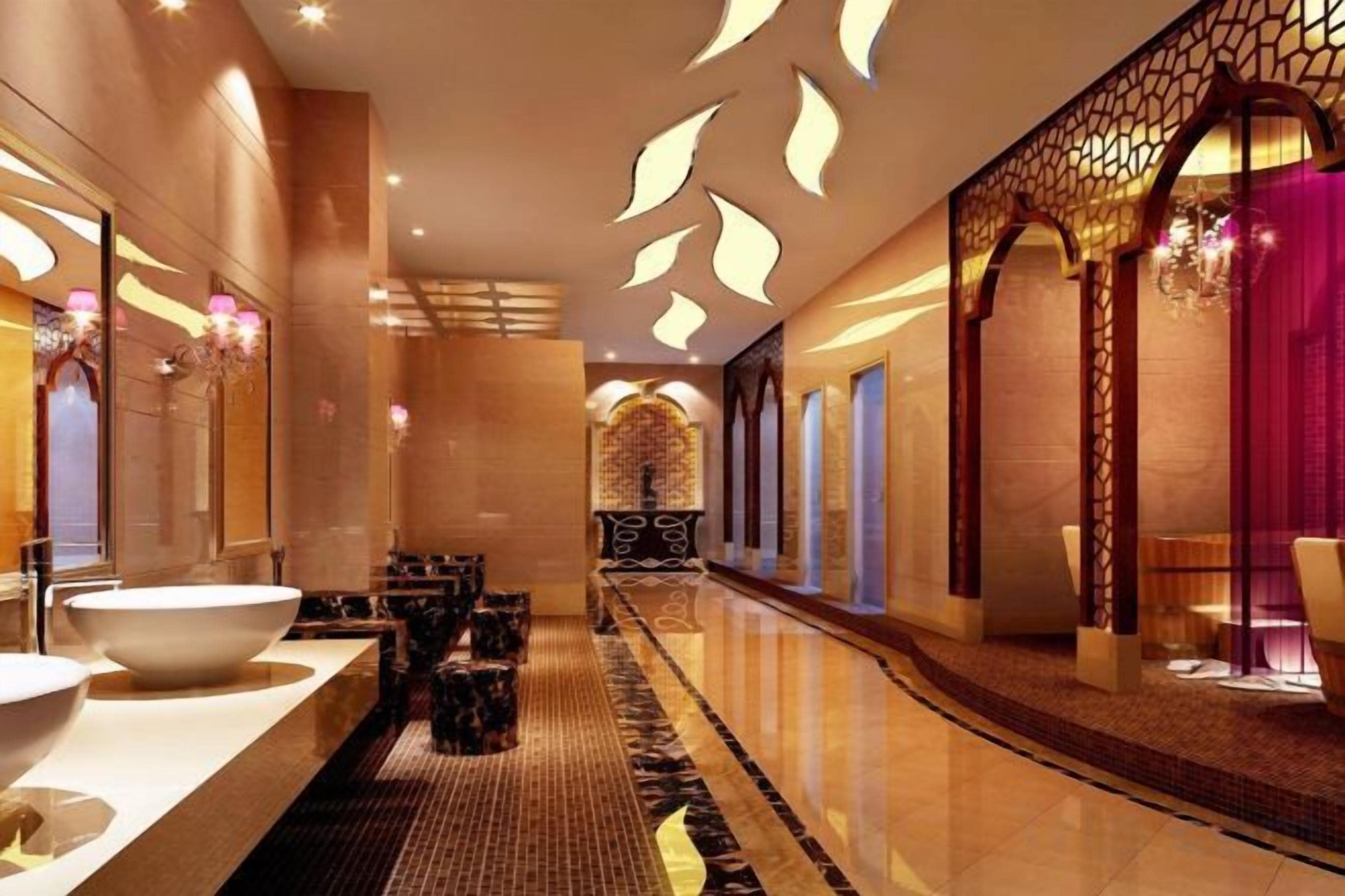 A modern hotel corridor with a long reception desk, a large white basin, and a patterned carpet.
