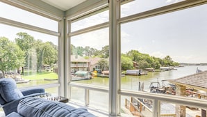 A spacious room with large windows overlooking a marina and water. - Exquisite Canal-Front Home: Access to Lake Conroe! (Montgomery)