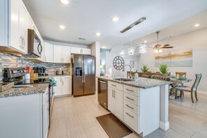 Enjoy cooking in this well-equipped kitchen with a large island, sink, and stainless steel appliances.