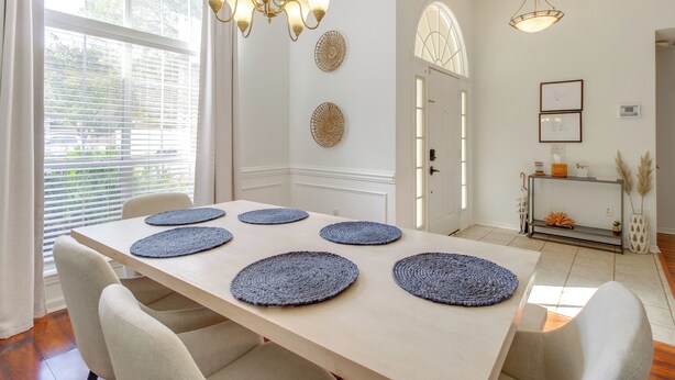 A dining area with a long table, six round placemats, and a chandelier. - Savannah Haven w/ Gazebo, Grill & Fire Pit (Savannah)