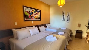 A hotel room with a large bed, a bedside table, a lamp, and a painting on the wall. - Pousada Villa Zen (Pirenópolis)