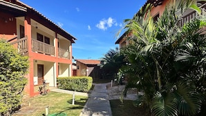 A pathway leading to a building with a red facade and balconies. - Pousada Villa Zen (Pirenópolis)