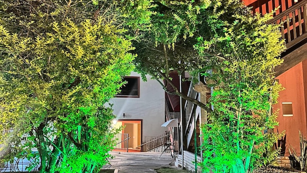 A pathway flanked by trees and buildings, leading to an entrance. - Pousada Villa Zen (Pirenópolis)