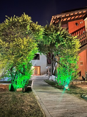 A pathway flanked by trees and buildings, leading to an entrance. - Pousada Villa Zen (Pirenópolis)
