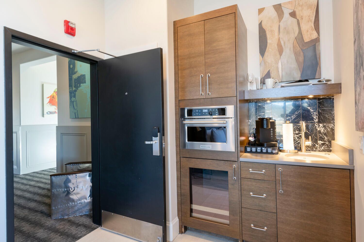 A modern kitchen with a built-in oven, a coffee machine, and a sink.