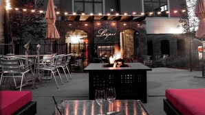 An outdoor seating area with tables and chairs, a fire feature, and string lights. - Lespri by Park City Vacations (Park City)
