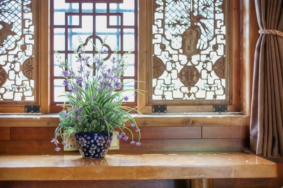 A potted plant on a wooden bench by a window with intricate stained glass.