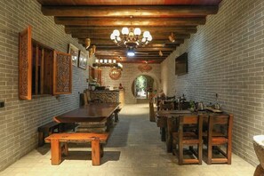 A long dining hall with brick walls, wooden benches, and a central table. - Huangyao Ancient Town (Zhaoping)