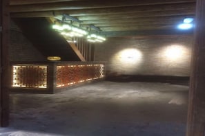 An underground room with brick walls, a wooden ceiling, and a brick partition with lights. - Huangyao Ancient Town (Zhaoping)