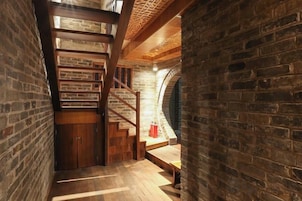 Una escalera con barandillas de madera y un muro de ladrillo.