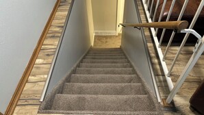A carpeted staircase with wooden trim and white railings.