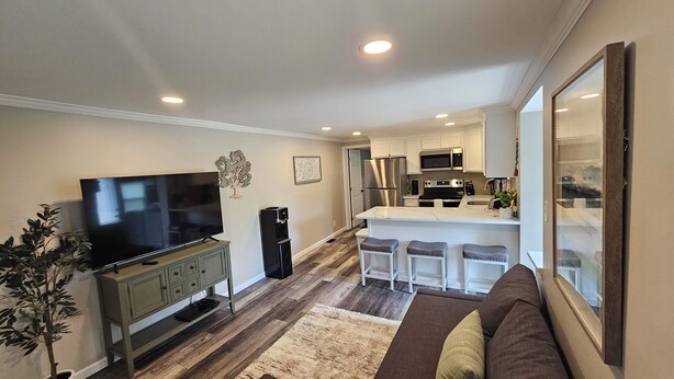A modern living room with a flat-screen TV, a sofa, and a coffee table.