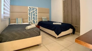 Un dormitorio con dos camas, un armario y un panel decorativo.