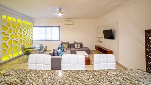 A modern living room with a sectional sofa, a dining area with a glass table, and a kitchen with granite countertops. - - Check-in from 3:00pm.<br>- Check-out before 11:00am.<br>- Smoking is not... (Puerto Vallarta)