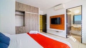 A modern hotel room with a large bed, a TV mounted on the wall, and a bathroom with a sink and mirror. - - Check-in from 3:00pm.<br>- Check-out before 11:00am.<br>- Smoking is not... (Puerto Vallarta)