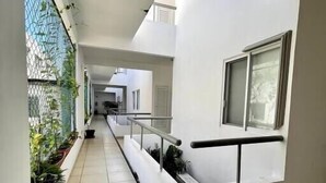 A corridor with a tiled floor, white walls, and a balcony with a railing. - - Check-in from 3:00pm.<br>- Check-out before 11:00am.<br>- Smoking is not... (Puerto Vallarta)