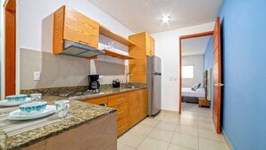A compact kitchen with wooden cabinets, a granite countertop, and a built-in refrigerator. - Perfect for couples! Great location in Versalles! (Puerto Vallarta)