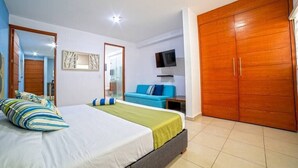 A bedroom with a bed, a TV, a wardrobe, and a mirror. - Perfect for couples! Great location in Versalles! (Puerto Vallarta)
