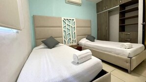 Une chambre d’hôtel avec deux lits, une armoire et un appareil de climatisation.