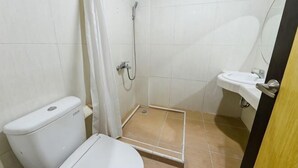 A bathroom with a toilet, shower, and sink. - RedDoorz @ Brother Homestay Kupang (Kupang)