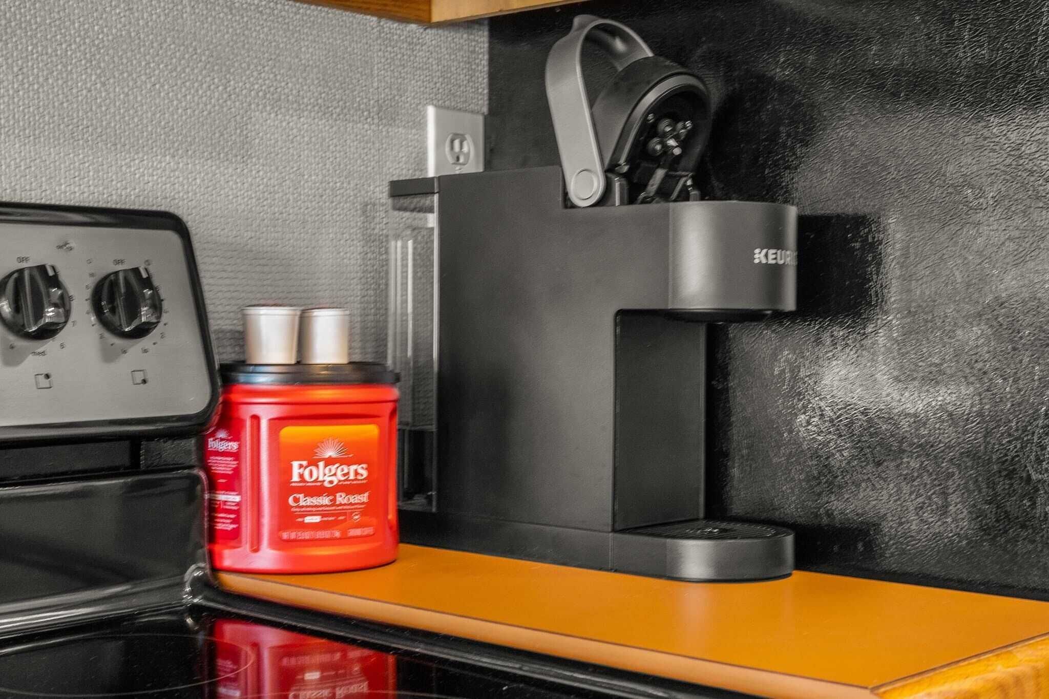 Une cuisine équipée d’une cuisinière, d’une machine à café et d’un paquet rouge de café Folgers Classic Roast.