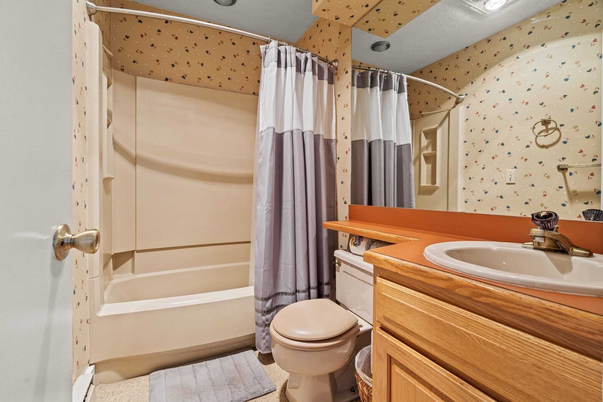 A bathroom with a bathtub, toilet, and sink.