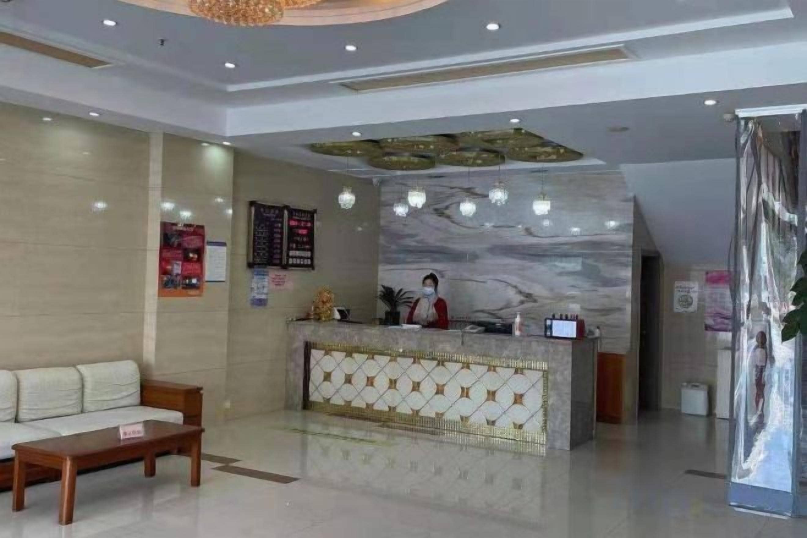 A hotel lobby with a reception desk, a sofa, and a coffee table.