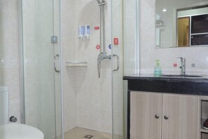 A modern bathroom with a glass-enclosed shower, a sink with a black countertop, and a mirror above it. - Shenzhou Business Hotel (Jinhu)
