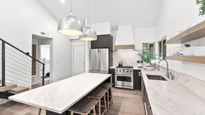 A modern kitchen with a central island, stainless steel appliances, and pendant lighting. - Creekside 3B/3B Townhome - 1 Block to Ski Lift! (Park City)
