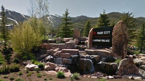 A sign for Park City Canyons Village with a mountainous backdrop. - Creekside 3B/3B Townhome - 1 Block to Ski Lift! (Park City)
