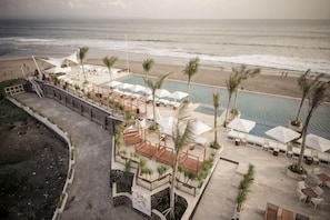 A resort with a pool, beach, and palm trees. - LV8 Resort Hotel Bali (Bali)